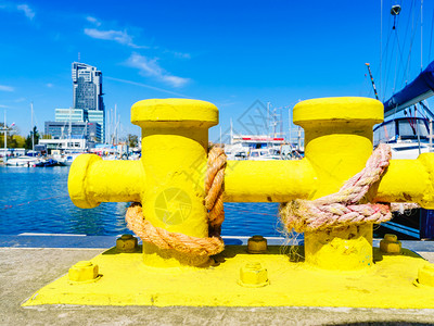 船运物体概念在黄色码头周围挂着的绳索阳光明媚的日子里外射杀在码头的波拉德背景图片