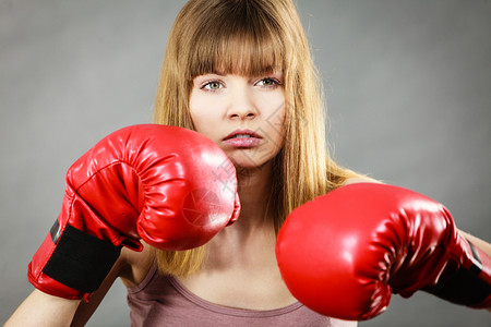 身着红拳击手套打斗身穿拳击手套的女运动员背景图片
