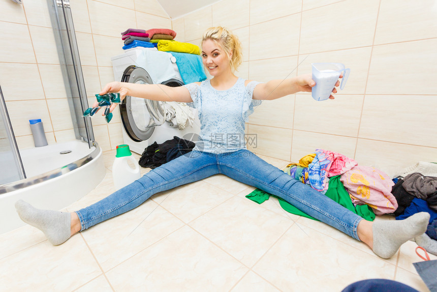 妇女洗浴室选择最好的洗涤剂妇女用奶粉容器和凝胶罐洗衣服家务宽视线女孩用不同的洗涤剂衣服图片