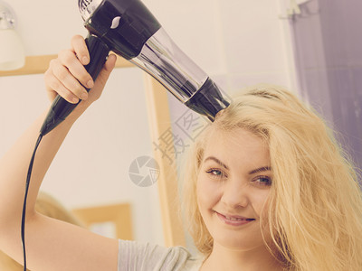 阳女人在金发头上用烘机理概念金女人用吹机背景图片
