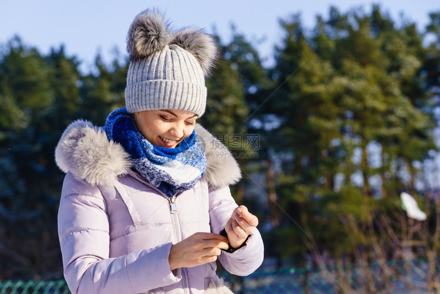 年轻美女在冬季穿着温暖的首饰女穿着灰色的豆热帽有蓬和粉红色夹克女穿着温暖的服装图片