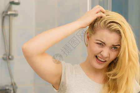 金发女人在洗手间里看着自己身上有油的头发有问题皮抓伤自己脱衣问题金发女人有问题头发背景
