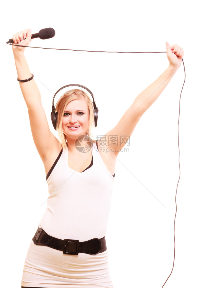 音乐激情概念工作室拍摄的金发年轻女子唱着麦克风头部戴大耳机唱着歌曲玩得开心与世隔绝图片