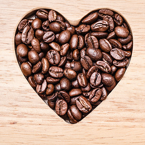 木板背景的心形咖啡豆图片