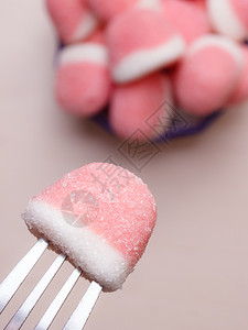甜食粉糖加手握叉子伸出从碗里取糖果图片