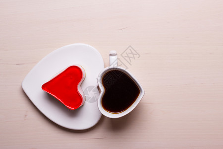 木表面的心形咖啡杯和果冻蛋糕顶视图复制文本空间图片