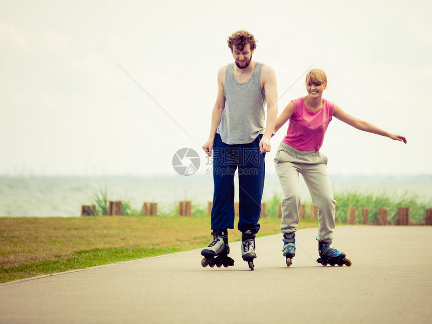 活跃的生方式和自由概念穿溜冰滑雪的年轻情侣在海边户外玩滑冰男女一起享受时间图片