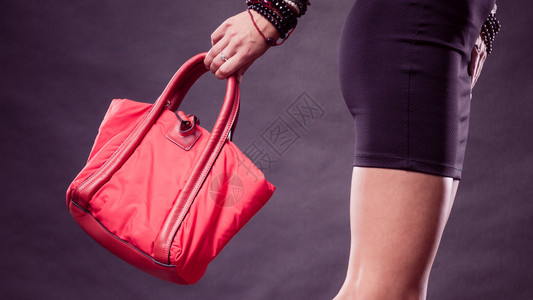 时装概念黑短裙衣妇女着红色手提袋图片