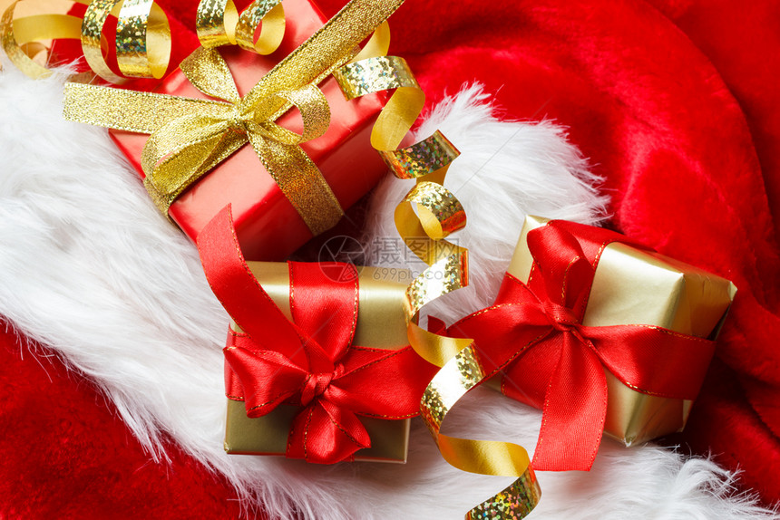 节日现圣诞节概念小盒装着礼物红背景上绑着弓图片