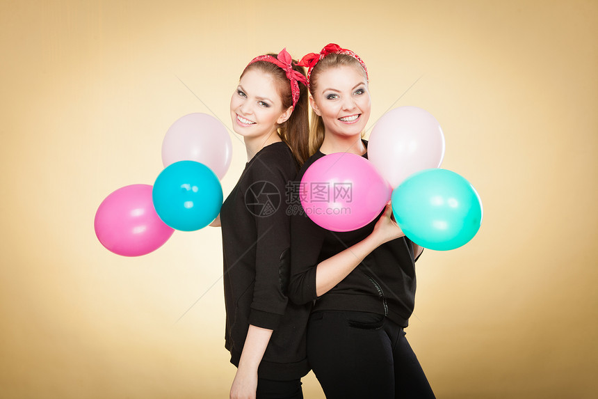 准备生日派对两位快乐的年轻女孩准备庆祝带着多色气球微笑的快乐女人图片