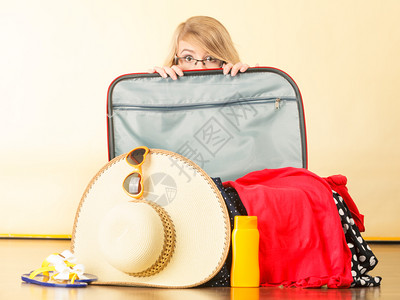年轻女士坐在地板上拿着手提箱装满东西准备在暑假吃年轻女士包装手提箱图片