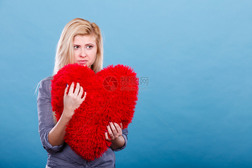 悲伤沮丧抱着大红毛发枕头的心型女她需要爱抱着红皮枕头的图片