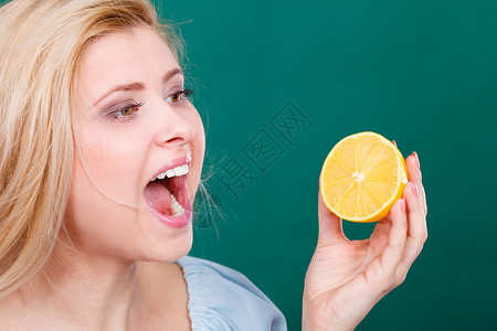 健康饮食新鲜品充满维他命张嘴的妇女拿着酸柑橘柠檬张嘴的妇女拿着柠檬图片