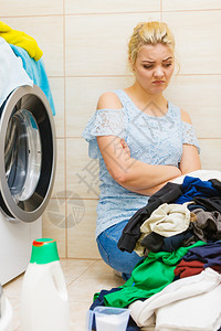 卫生间里有一堆脏衣服的不开心女人洗衣的概念勤劳脏活家务图片