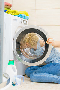 女人在洗衣机门内看调查洗涤浴室内液女人在洗衣机内看图片