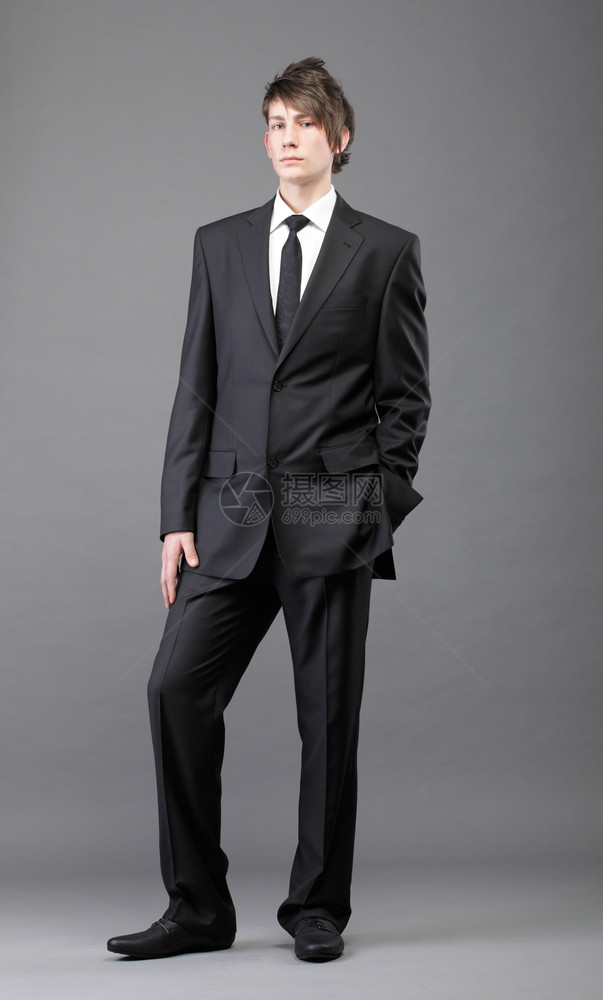 时装年轻商人黑西灰色背景的散衣领带图片