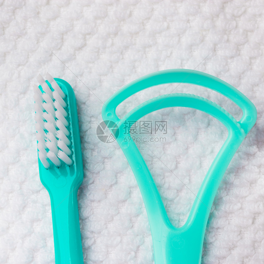 口腔卫生保健概念关闭牙科工具绿色刷和白毛巾上的舌清洁剂图片