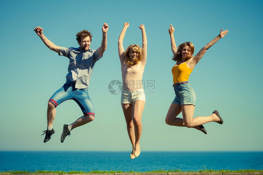 无忧虑的年轻朋友跳过海水幸福的男女快乐的夏天幸福和自由快乐的朋友们跳过海水图片