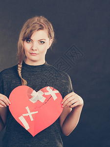 治愈的爱情人节概念微笑年轻女人带着大红心的石膏女朋友愈合关系图片
