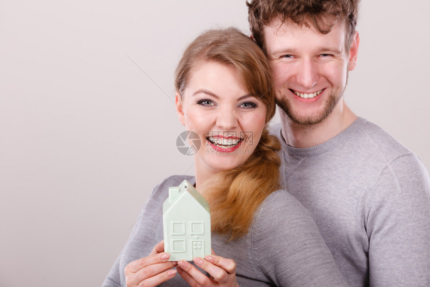 未来住房家庭抵押贷款融资概念有家庭模型的年轻夫妇有家庭标志的年轻男女笑容有家庭模型的年轻夫妇图片