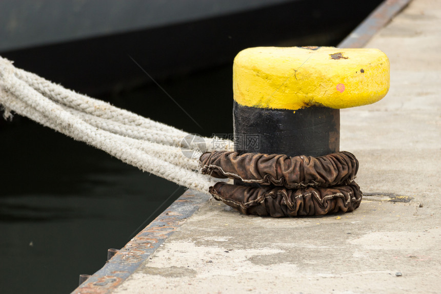 装有绳索的黄系紧船壳装在坞的底座上图片