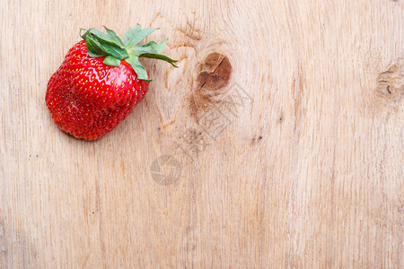 红鲜单草莓果在木制板上复空间文字区域图片