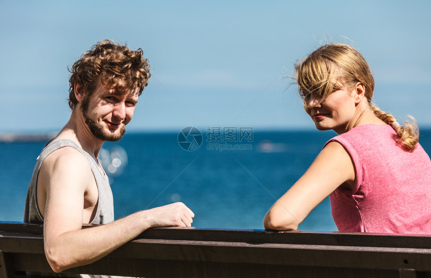 一对夫妇在海边约会露天年轻女孩和男人坐在长凳上夏天的爱夫妇和女人在户外约会图片