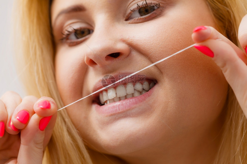 每天口腔卫生牙科妇女用牙线清理牙齿图片