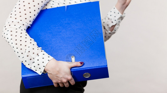 妇女手持许多文件的蓝色夹子办公室簿记物品概念图片