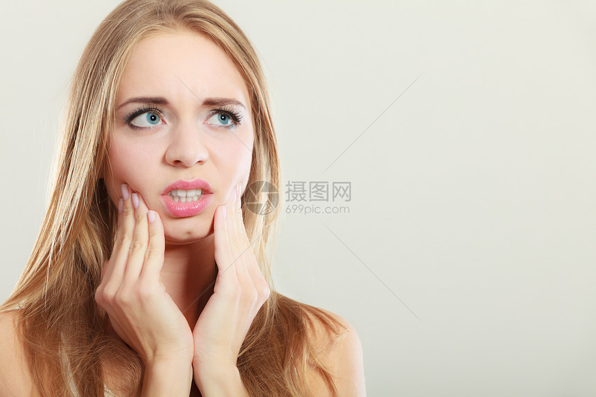 关紧身的年轻女子面临患牙痛的担心女童图片