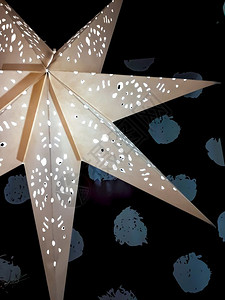 观赏大明星装饰灯泡在黑暗背景的灯泡在圣诞节的黑暗背景图片