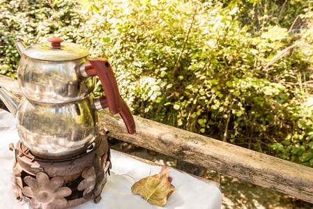 萨莫瓦尔土耳其传统茶叶在木制餐桌的火炉上做锅背景