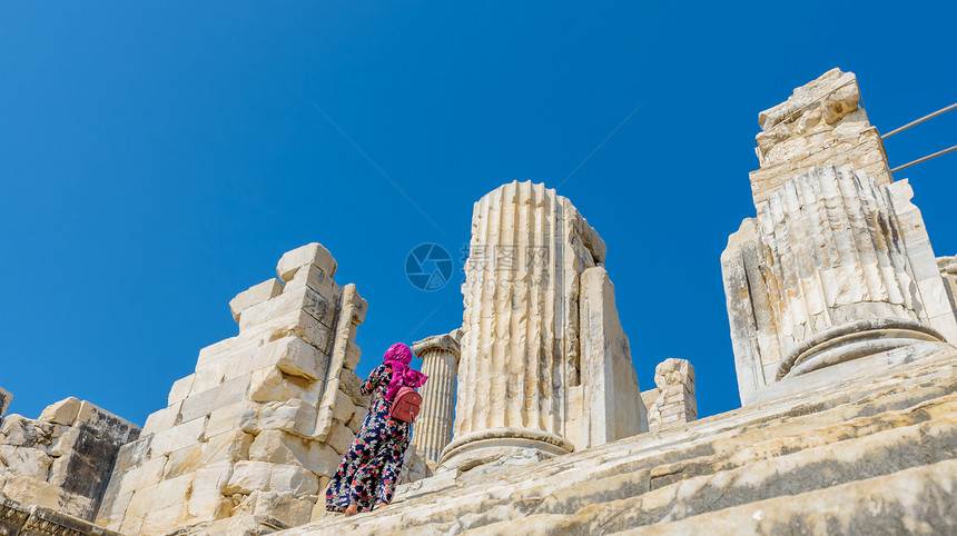 不明身份的妇女走在土耳其艾丁的迪姆马阿波罗寺的阶梯上在土耳其艾丁的迪姆马阿波罗寺图片
