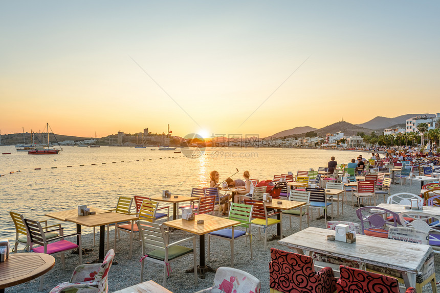 2017年8月3日土耳其博德鲁姆海滩咖啡馆和博德鲁姆海洋日落风景中有游艇和圣彼得城堡或博德鲁姆风景中有身份不明的人享受图片