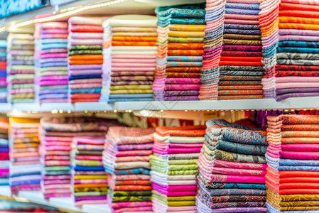 传统多彩丝绸卡什米尔头巾或披和织物由土耳其伊斯坦布尔集市摊铺的堆叠背景构成丝绸卡什米尔头巾或由堆叠组成的围巾和织物背景