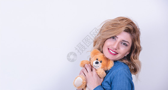 迷人的美丽模特女拥抱棕色泰迪熊礼物图片