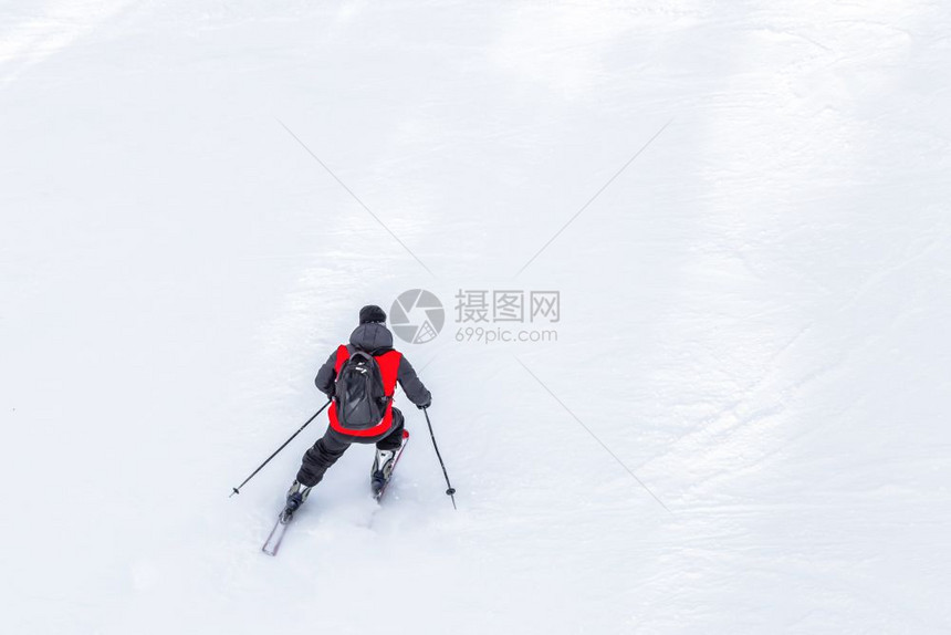 红大衣和黑色背包滑雪手者在Sunny冬日滑雪斜坡上者在土耳其的uludag山布尔萨Bursa有复制空间红大衣和黑色背包滑雪者有红图片