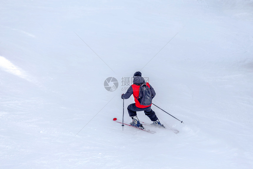 红大衣和黑色背包滑雪手者在Sunny冬日滑雪斜坡上者在土耳其的uludag山布尔萨Bursa有复制空间红大衣和黑色背包滑雪者有红图片