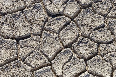 碎裂的土壤纹理背景顶部视图盐沙漠以浅色在地面上裂缝碎的土壤纹理背景与浅色背景图片