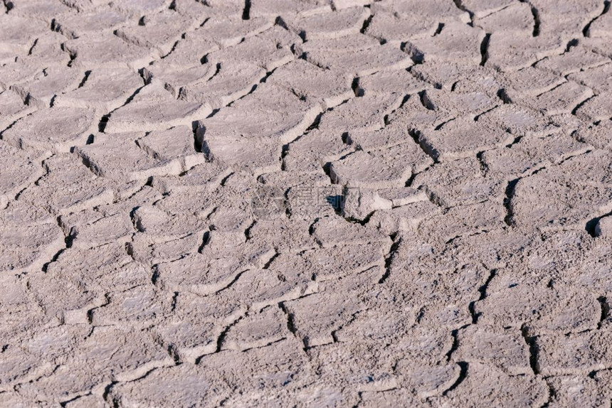 碎裂的土壤纹理背景顶部视图盐沙漠以浅色在地面上裂缝碎的土壤纹理背景与浅色图片