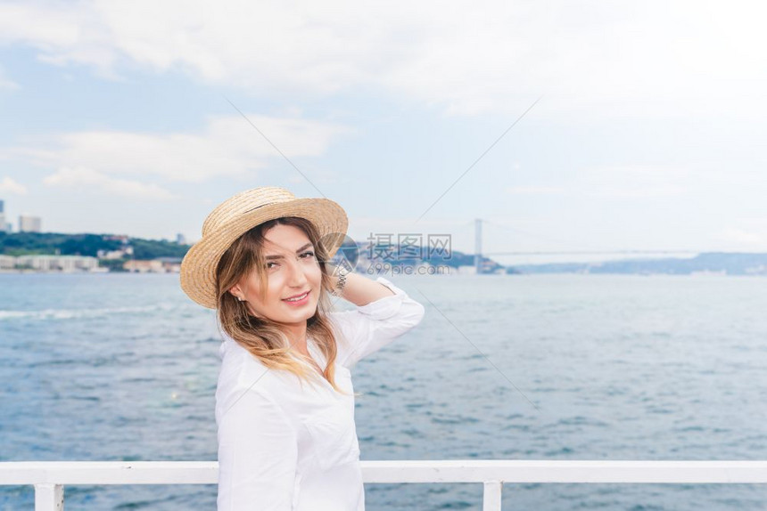 身着红裙子的美女在伊斯坦布尔的渡轮上旅行图片