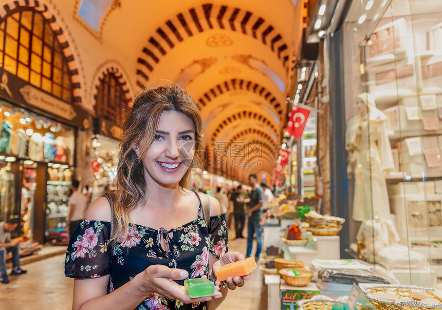 美丽的女看起来像传统肥皂由天然草药制成在埃及的Bazaar在土耳其伊斯坦布尔的Eminonu出售图片
