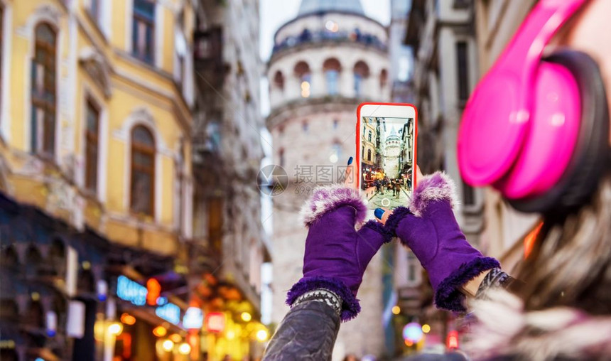 土耳其伊斯坦布尔贝奥格鲁一位戴着耳机的美女在拍加拉塔的照片身着红色连衣裙的美女坐在伊斯坦布尔的渡船上图片