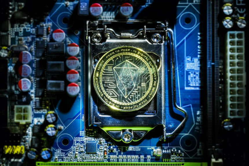计算机母板处理器上金色的Eos加密硬币的顶端视图Bitcoin采矿场计算机设备概念图片
