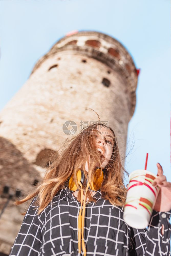 土耳其伊斯坦布尔贝奥格鲁美丽迷人快乐的年轻时尚女孩的肖像俯瞰加拉塔身着红色连衣裙的美女坐在伊斯坦布尔的渡船上图片