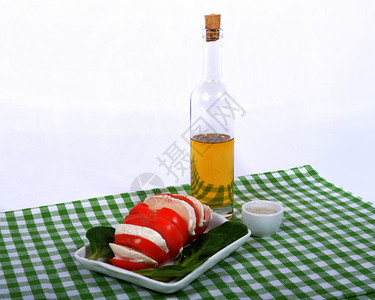 番茄沙拉绿毛巾上加一瓶橄榄油图片