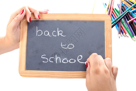一个女孩在黑板上写回学校背景图片