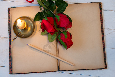 旧笔记本玫瑰和小蜡烛一个浪漫的概念背景图片