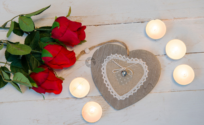 一个浪漫的概念三个红玫瑰心脏和蜡烛图片
