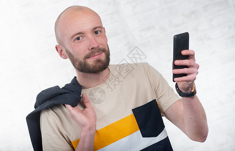 长胡子和黑智能手机说话的年轻人图片
